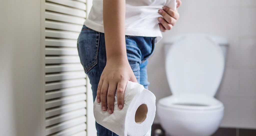 Woman Holding a Tissue Paper in the Bathroom due to Diarrhea
